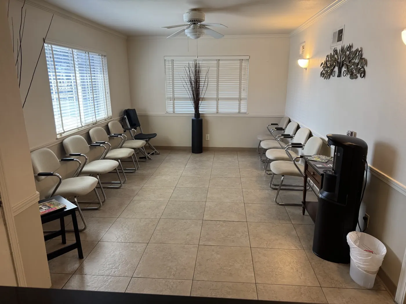 Waiting room at the Manteca chiropractic office with seating along both walls, natural light, and a water cooler