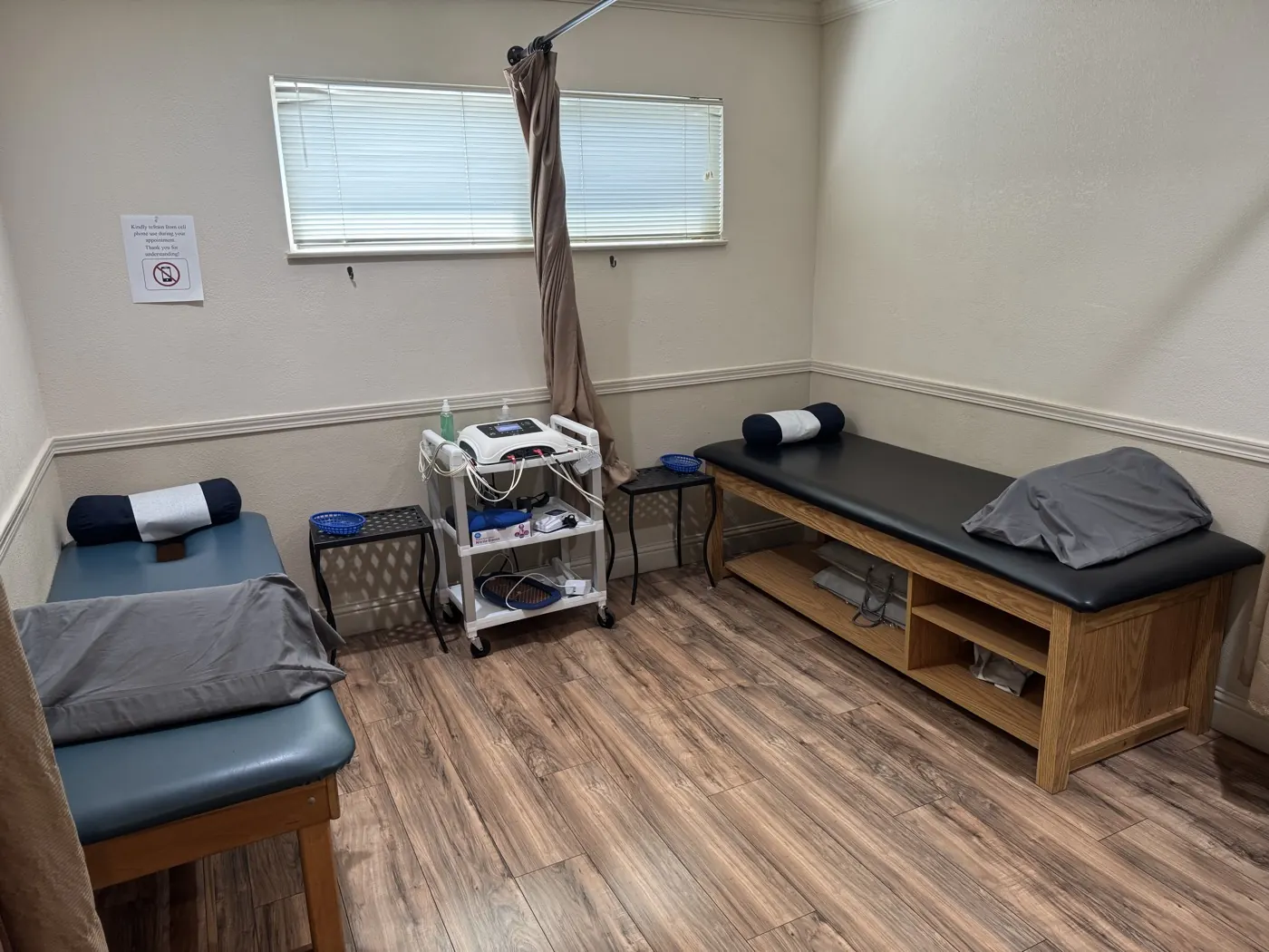 Therapy room at the Manteca office with two treatment tables and an electrical stimulation unit on a rolling cart