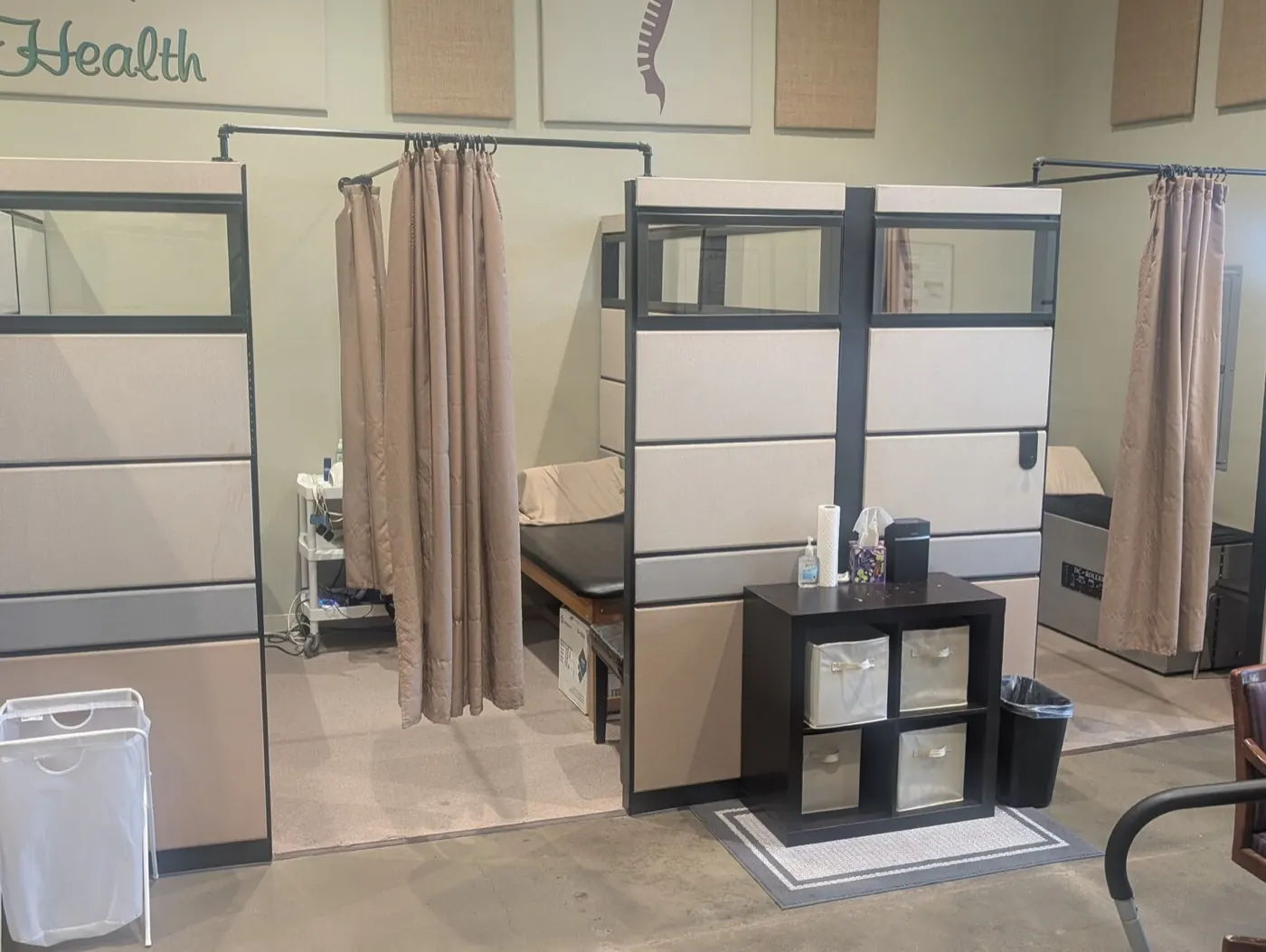 Curtained therapy bays at the Mountain House office, each with its own treatment table for private care