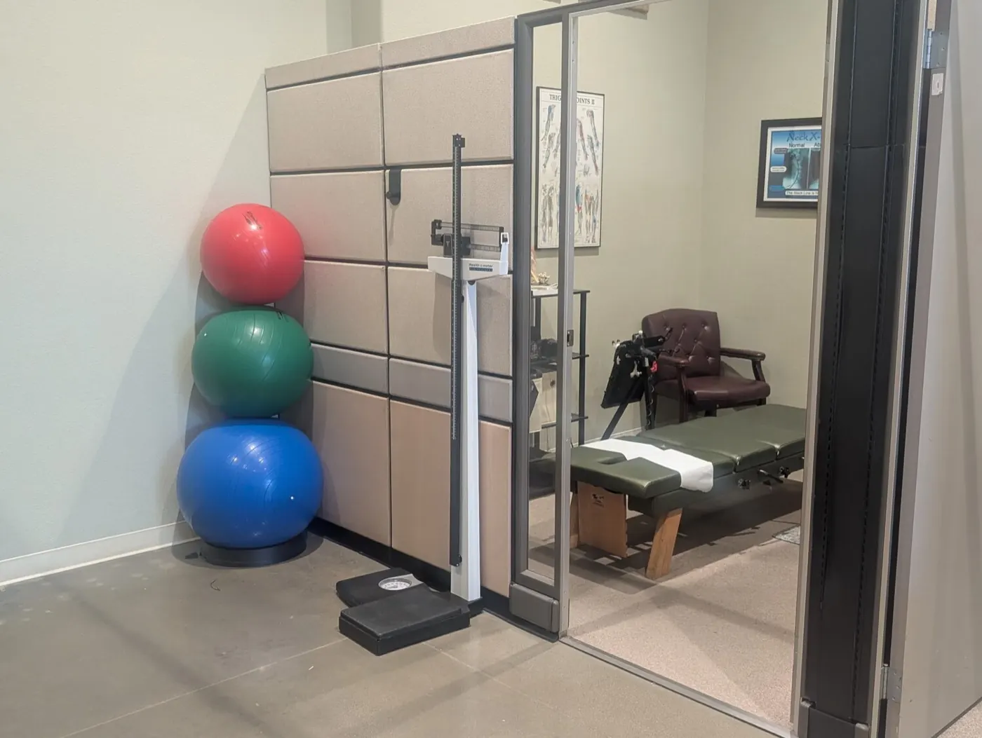 Exercise and measurement area at the Mountain House office with stability balls, a height and weight scale, and an adjusting room beyond