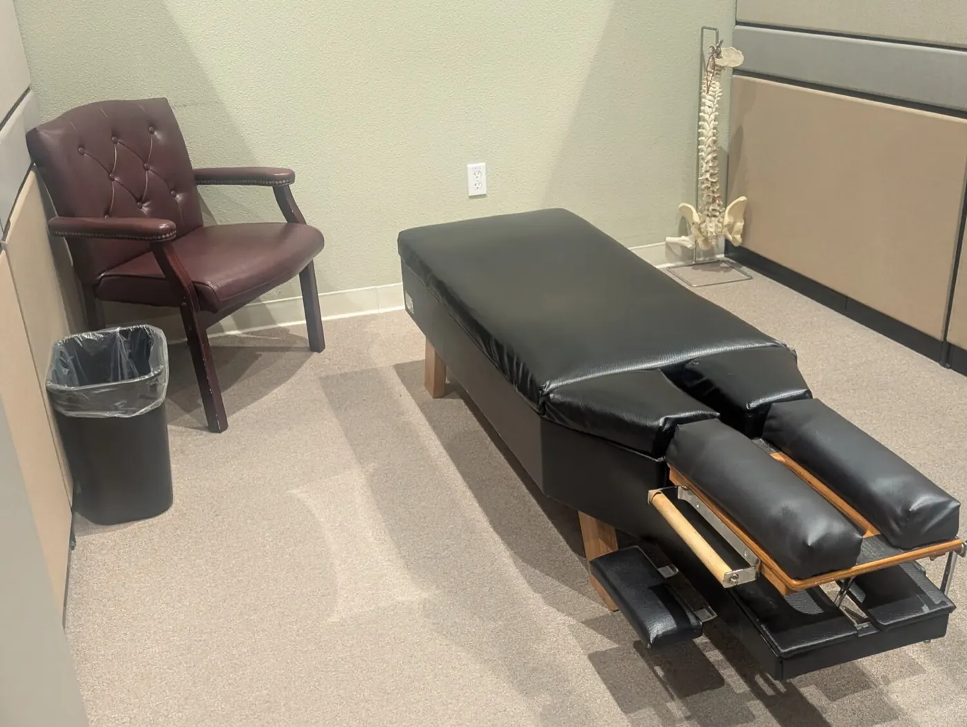 Adjusting bay at the Mountain House office with a black drop table and a spine model in the corner