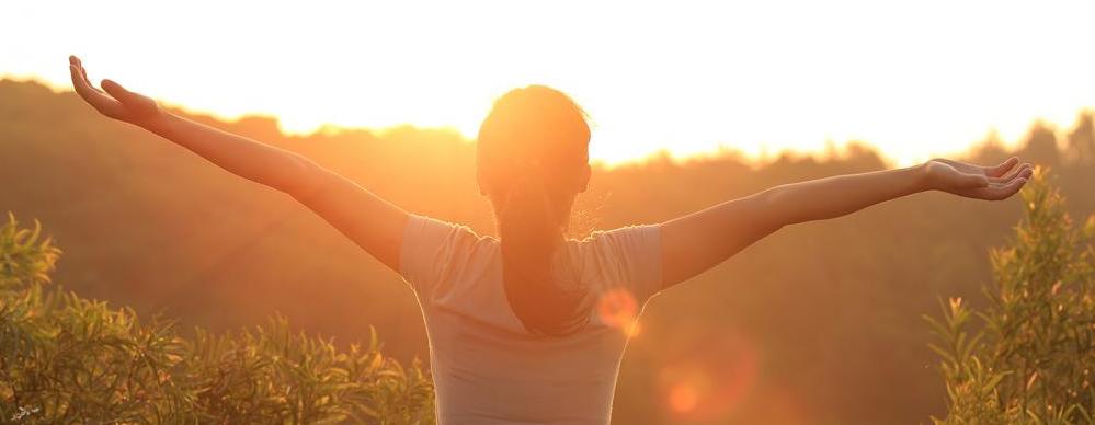 Woman standing in sunset after seeing Tracy CHiropractor