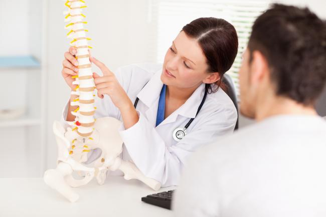 chiropractor showing model of the spine in Tracy, CA